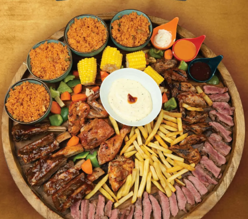 Sharing meat platter with grilled cuts, sides and sauces